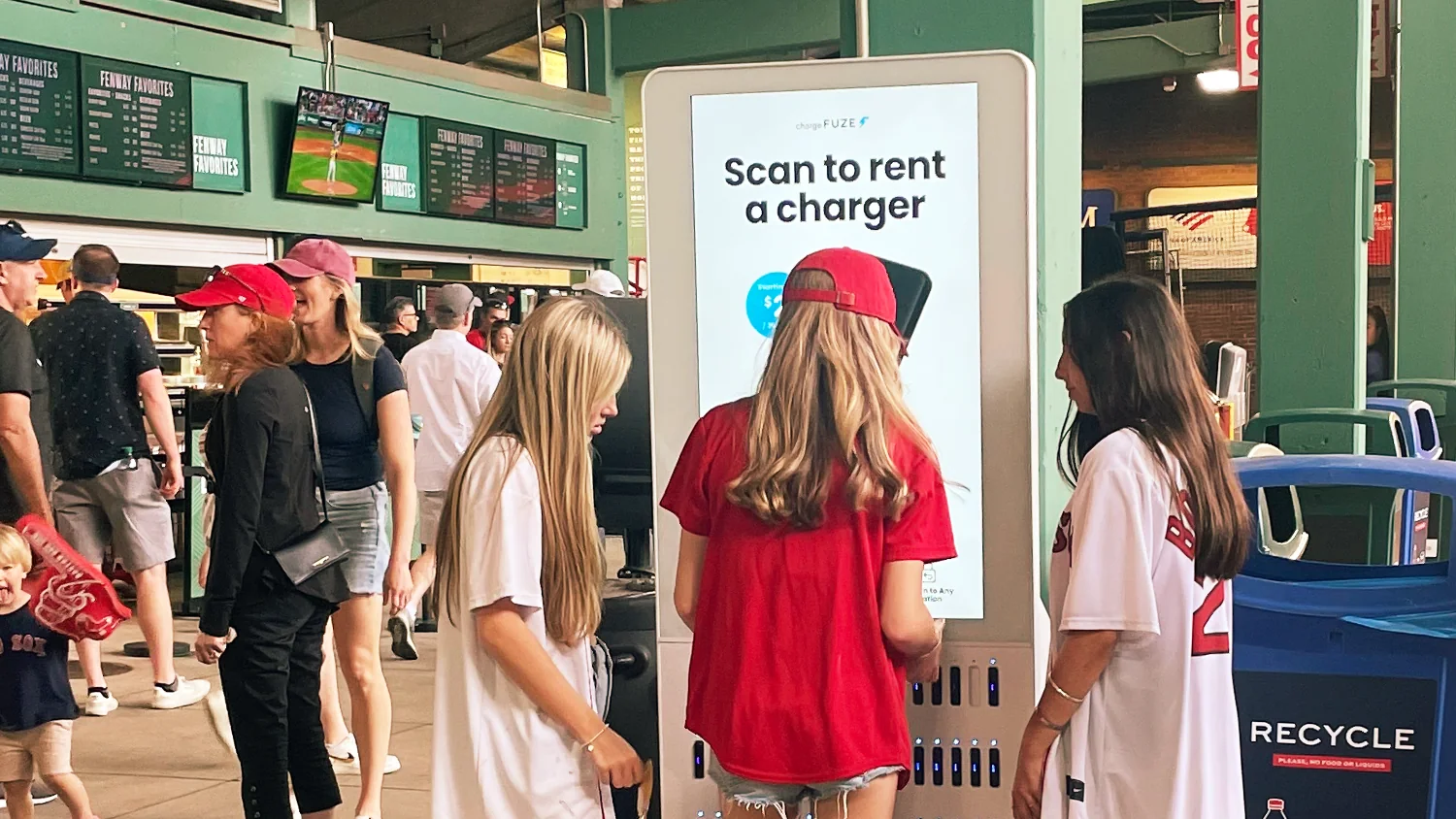 Fans renting chargers at a Chargefuze station on a ballpark concourse
